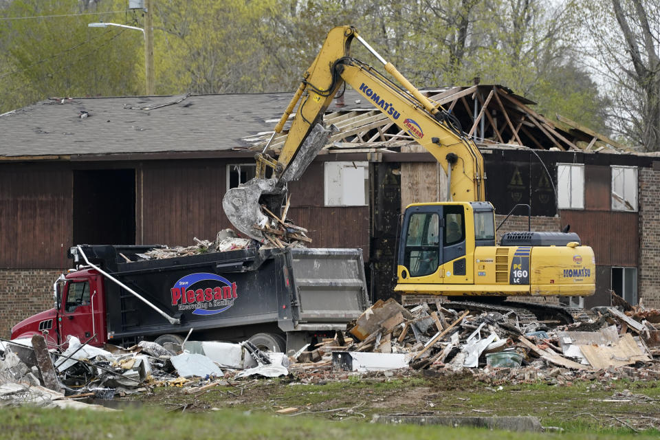 CORRECTS STATE TO KENTUCKY INSTEAD OF TENNESSEE - Debris is removed from buildings damaged in a Dec. 10 tornado on April 21, 2022, in Dawson Springs, Ky. Four months after a massive tornado tore through the state, hundreds of Kentuckians are arduously reconstructing their pre-storm existence. (AP Photo/Mark Humphrey)