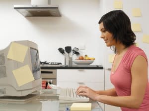 Woman using computer, post-it notes everywhere