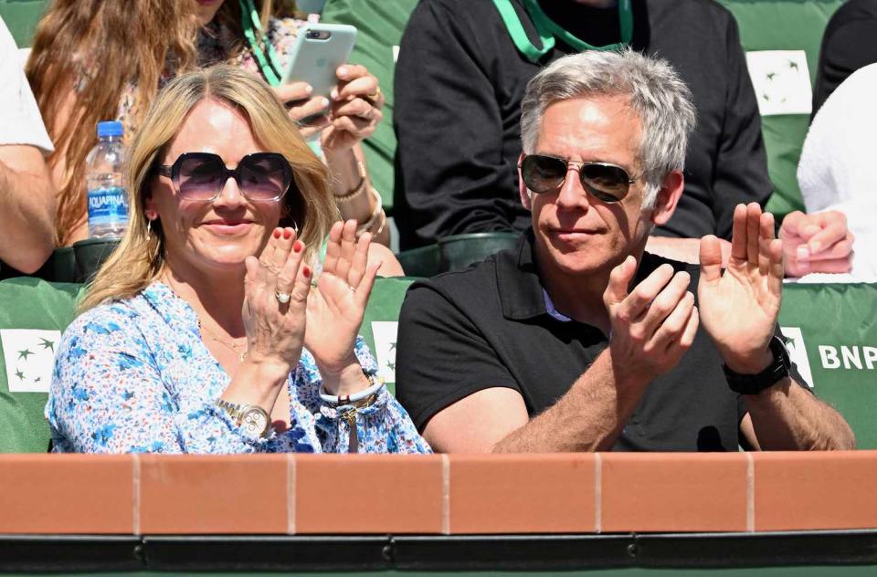 Christine Taylor and her husband Ben Stiller applaud from the stands after Rafael Nadal of Spain won a point during a tennis match against Reilly Opelka of the United States played on March 16, 2022 at the BNP Paribas Open at the Indian Wells Tennis Garden in Indian Wells, CA