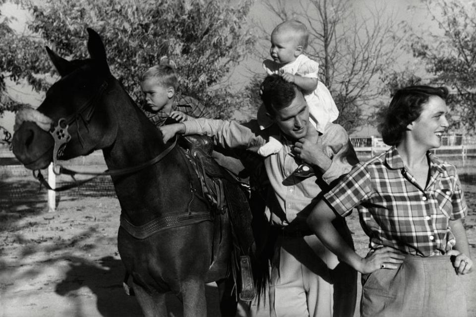 George H. W. Bush with his wife, Barbara, and their children Pauline (Robin) and George W. on horse in the yard of their Midlands, Texas ranch