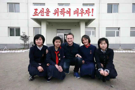 Canadian businessman Michael Spavor poses with girls at a school in Rason Special Economic Zone, North Korea, 2012. The Korean characters behind read "Let's study for Korea!" REUTERS/James Pearson