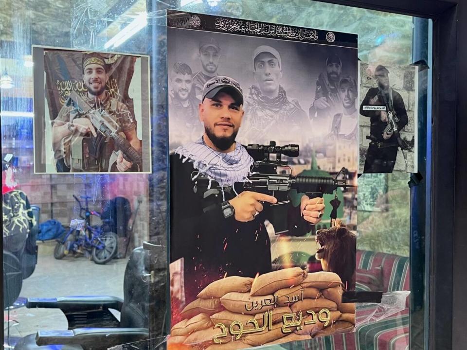 A poster featuring the images of slain members of a militant group known as the Lions' Den is seen on the window of a barber shop in the Old City of Nablus, West Bank. (Stephanie Jenzer/CBC - image credit)