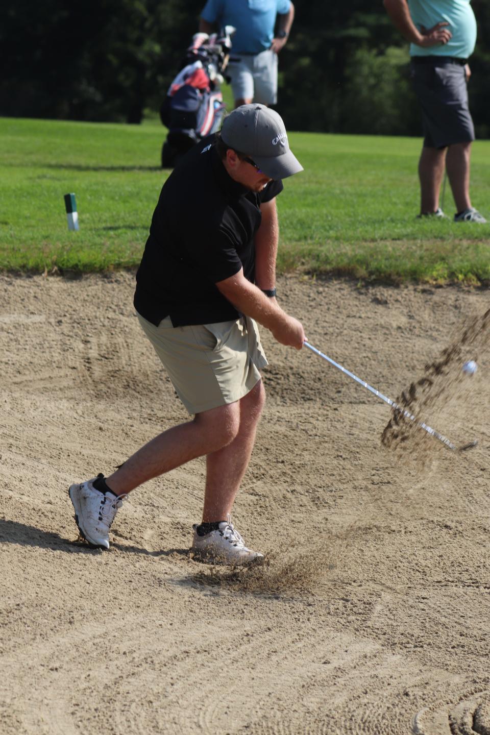 Runner-up Andrew Johnson blasts out of the greenside bunker on the 18th hole to within four feet of the cup.