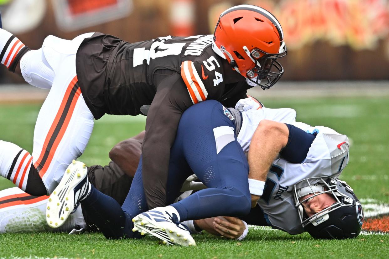 Tennessee Titans quarterback Ryan Tannehill, right, is sacked by Cleveland Browns defensive ends Ogbo Okoronkwo (54) and Myles Garrett, behind, on Sept. 24 in Cleveland.