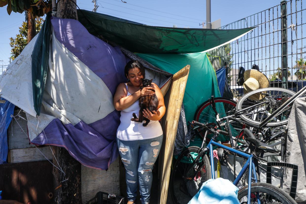 Rebecca Chavez, who was part of the Inside Safe unhoused program but now lives on the streets, holds her cat Chicote on Aug. 2, 2023.
