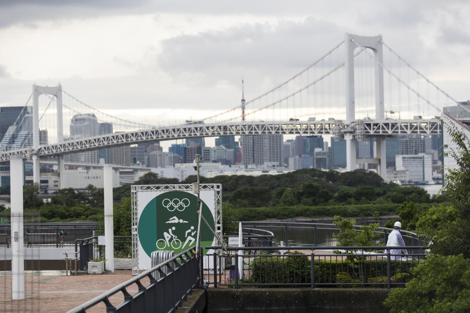 A guard, lower right, walks around a park being prepared for the Olympics and Paralympics Games in Tokyo on Thursday, July 1, 2021. (AP Photo/Hiro Komae)