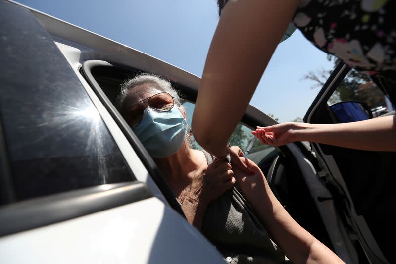 IMAGEN DE ARCHIVO. Una trabajadora de la salud administra una dosis de la vacuna CoronaVac contra el COVID-19 en un centro de vacunación en automóviles, en Santiago, Chile