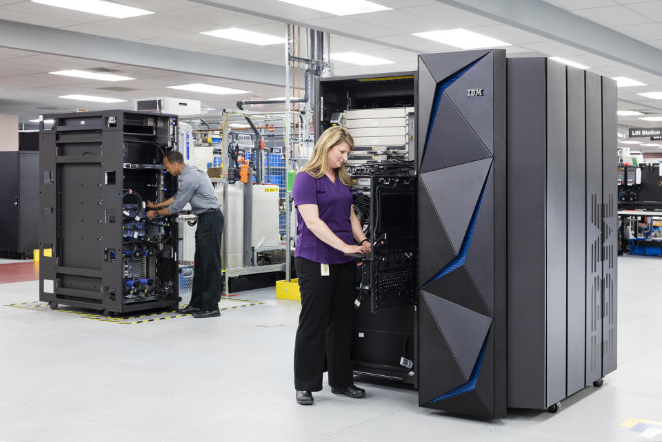 Two technicians standing in front of IBM Z servers.