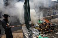 An Ultra-Orthodox Jewish man burns leaven in the Mea Shearim neighbourhood of Jerusalem ahead of the Jewish holiday of Passover