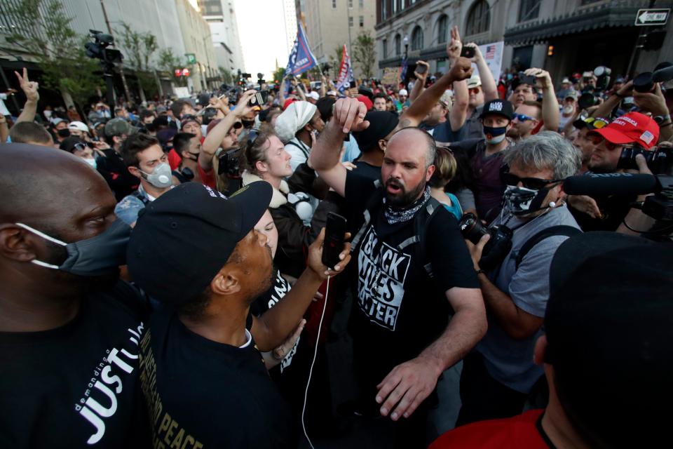 Protesters and supporters clash near the BOK Center in Tulsa, Okla., where President Donald Trump held a campaign rally last Saturday. The Oklahoma Department of Health urged anyone who has recently attended a large-scale event to be tested for the novel coronavirus.