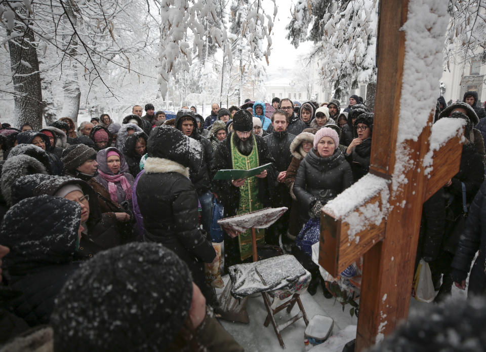 A group of Orthodox Christian believers led by Moscow-appointed clerics hold prayers outside the Ukrainian parliament and protest the formation of an independent Ukrainian Orthodox Church in Kiev, Ukraine, Friday, Dec. 14, 2018. The Russian Orthodox Church has called on the United Nations, the leaders of Germany and France, the pope and other spiritual leaders to protect believers in Ukraine in the face of official pressure on Moscow-appointed clerics. (AP Photo/Serhii Nuzhnenko)