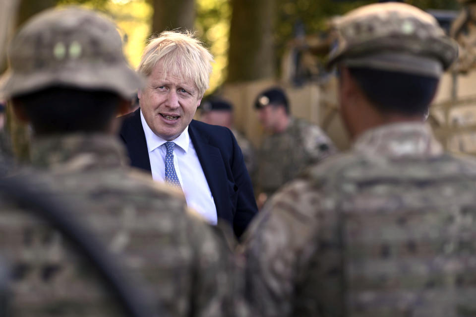 Britain's Prime Minister Boris Johnson talks to Ghurkas as he meets with military personnel on Salisbury Plain training area near Salisbury, England, Thursday, Sept. 19, 2019. British Prime Minister Boris Johnson was accused by a one of the country’s former leaders of a “conspicuous” failure to explain why he suspended Parliament for five weeks, as a landmark Brexit case at the U.K. Supreme Court came to a head on Thursday. (Ben Stansall/Pool Photo via AP)