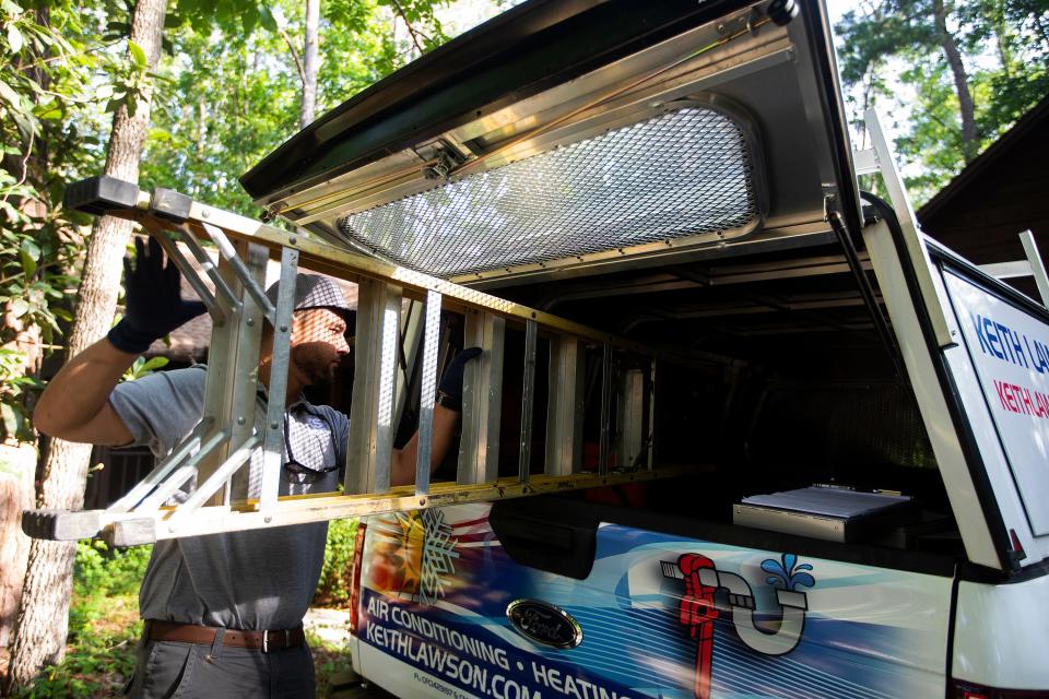 Brandon Medina of Keith Lawson Services places a ladder in his truck after servicing a residential air conditioning unit on Thursday, June 16, 2022 in Tallahassee, Fla. 