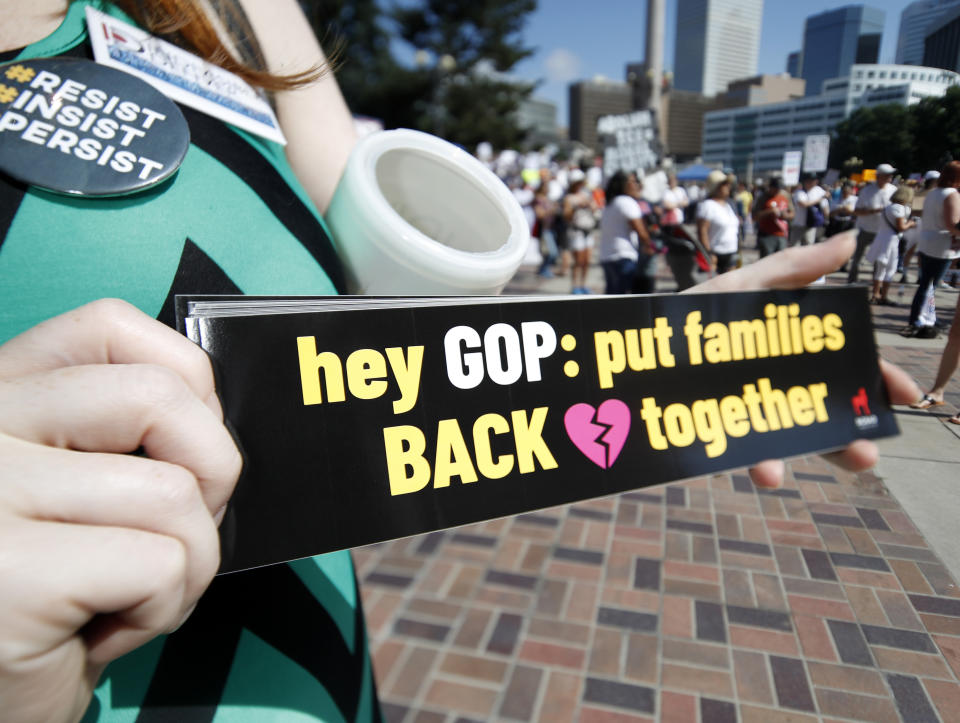 <p>Samantha Montgomery of Denver holds up a sign during an immigration rally and protest in Civic Center Park Saturday, June 30, 2018, in downtown Denver. (Photo: David Zalubowski/AP) </p>