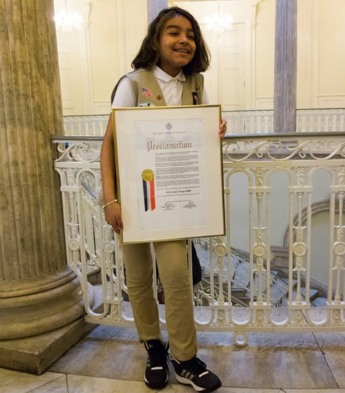 Karina, a member of Girl Scout Troop 6000, poses with the troop's proclamation