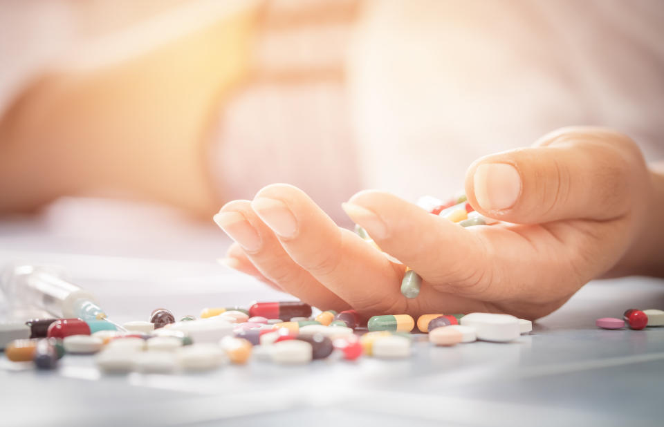 Overdose - close up of pills and addict lying on the floor