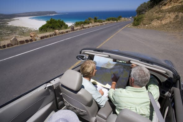 Mature couple looking at map in car