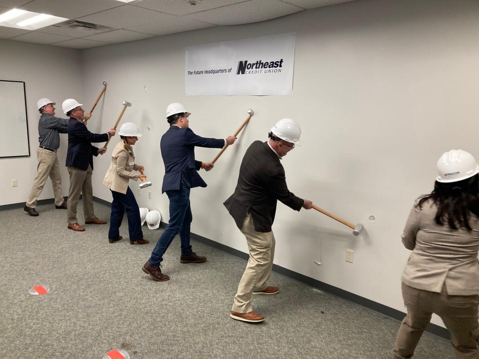 Northeast Credit Union leaders swing sledgehammers at a wall inside a 100 Education Way building in Dover on Thursday, Oct. 19, 2023. The building will serve as the company's new headquarters for years to come.