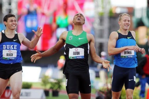 Ashton Eaton (C) celebrates after breaking the world record in the men's decathlon after competing in the 1,500m at the US Olympic Track and Field Team Trials on June 23