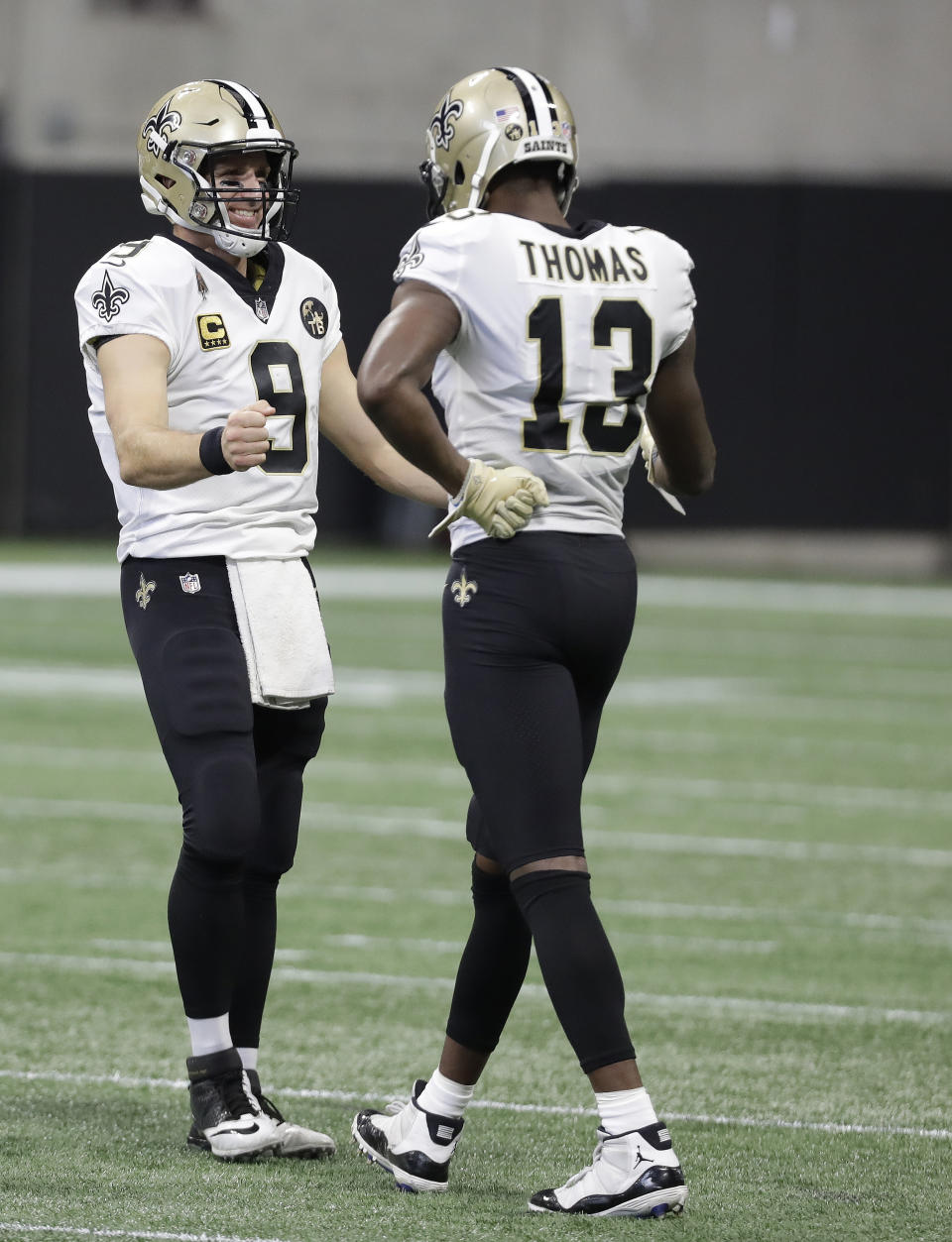 New Orleans Saints quarterback Drew Brees (9) celebrates his pass to New Orleans Saints wide receiver Michael Thomas (13) against the Atlanta Falcons during the first half of an NFL football game, Sunday, Sept. 23, 2018, in Atlanta. Brees' pass competition to Thomas for 17 yards broke Brett Favre's record for most past completions in a career with his 6,301 completion. (AP Photo/Mark Humphrey)