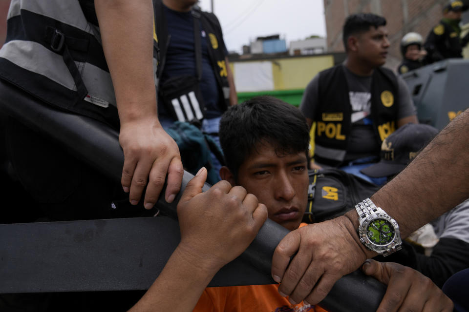 Un manifestante antigubernamental detenido se sienta en la parte trasera de una camioneta de la policía en la Universidad de San Marcos en Lima, Perú, el sábado 21 de enero de 2023. La policía desalojó de los terrenos de la universidad a los manifestantes que llegaron de las regiones andinas en busca de la renuncia de la presidenta Dina Boluarte, la excarcelación del derrocado presidente Pedro Castillo y elecciones inmediatas. (Foto AP/Martín Mejía)