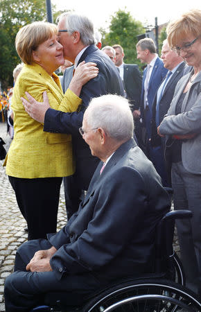 German Chancellor Angela Merkel greets European Commission President Jean-Claude Juncker as they congratulate German Finance Minister Wolfgang Schaeuble during a gala reception organised by the CDU in Baden-Wuerttemberg to mark Schaeuble's 75th birthday in Offenburg, Germany, September 18, 2017. REUTERS/Kai Pfaffenbach