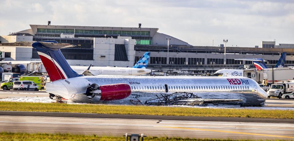 A Red Air plane that caught fire after the front landing gear collapsed upon landing is seen at Miami International Airport in Miami, after arriving from Santo Domingo, Dominican Republic, Tuesday, June 21, 2022. (Pedro Portal/Miami Herald via AP)