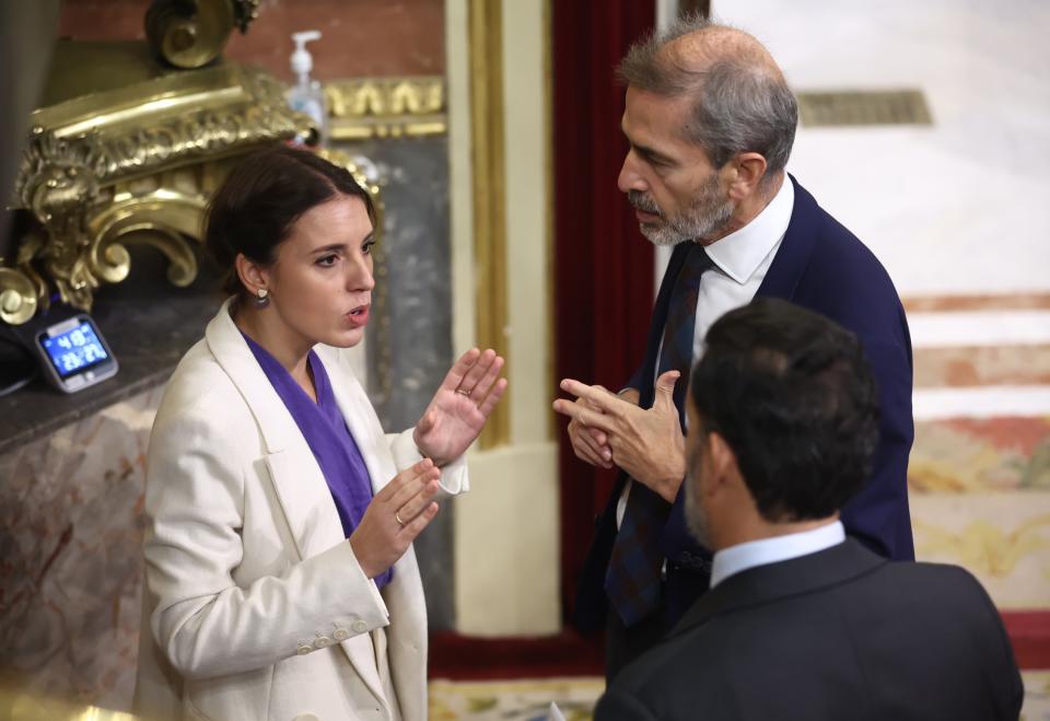 Irene Montero (Podemos) dialoga con los diputados del PP Carlos Aragonés y Guillermo Mariscal en un receso del debate parlamentario del Congreso.