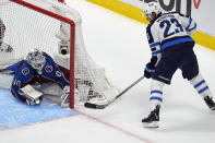 Colorado Avalanche goaltender Alexandar Georgiev, left, stops a wraparound shot by Winnipeg Jets center Sean Monahan during the first period of Game 3 of an NHL hockey Stanley Cup first-round playoff series Friday, April 26, 2024, in Denver. (AP Photo/David Zalubowski)