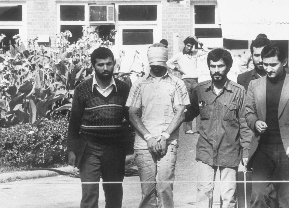 FILE - One of the hostages held at the U.S. Embassy in Tehran, Iran, is shown to the crowd by Iranian students Nov. 8, 1979. The upcoming prisoner swap between Iran and the United States follows the same contours that the countries have tracing since the resolution of the 1979 U.S. Embassy takeover and hostage crisis. The limits of this diplomacy remain largely the same as they have been for over the four decades since, with officials in both countries even using similar language to discuss the deals now. (AP Photo, File)