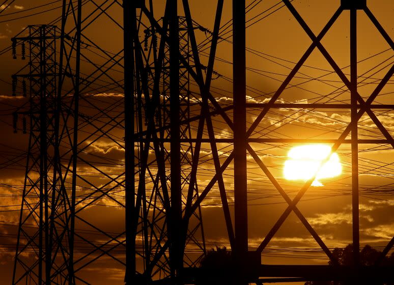 LONG BEACH, CALIF. - AUG. 16, 2022. The sun sets behind power lines on a warm afternoon in Long Beach, where temperatures reached into the low 80s on Tuesday, Aug. 16, 2022. The first statewide flex alert is scheduled for Wednesday, Aug. 17, 2022, as hot weather is expected to create demand on the power grid. (Luis Sinco / Los Angeles Times)