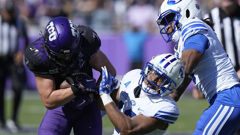 TCU wide receiver JP Richardson, left, breaks a tackle against BYU safety Malik Moore, center, and cornerback Eddie Heckard, during a college football game on Saturday, Oct. 14, 2023, in Fort Worth, Texas.