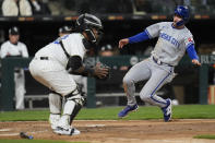 Kansas City Royals' Nick Loftin, right, slides by Chicago White Sox catcher Martín Maldonado to score on a single from Kyle Isbel during the fifth inning of a baseball game Monday, April 15, 2024, in Chicago. (AP Photo/Erin Hooley)
