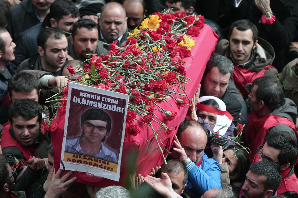 People carry the coffin of Berkin Elvan, a Turkish teenager who was in a coma since being hit on the head by a tear gas canister fired by police during anti-government protests in the summer of 2013, during his funeral in Istanbul, Turkey, Wednesday, March 12, 2014. On Wednesday, thousands converged in front of a house of worship calling for Prime Minister Recep Tayyip Erdogan to resign. The placard reads: " Berkin Elvan is immortal!" (AP Photo/Emrah Gurel)