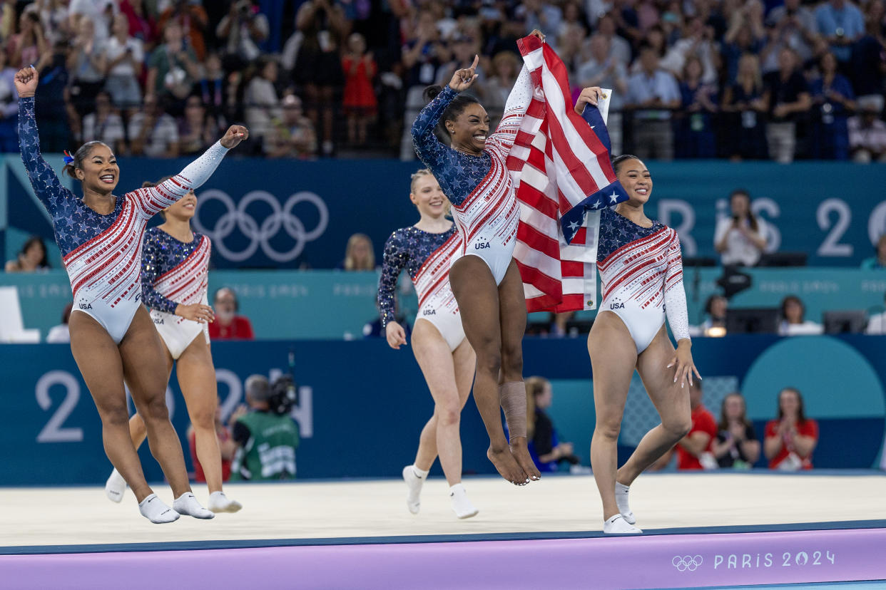 Simone Biles and Sunisa Lee lead Tuesday's gold medal celebration with teammates Jordan Chiles, Jade Carey and Hezly Rivera. (Tim Clayton/Corbis via Getty Images)