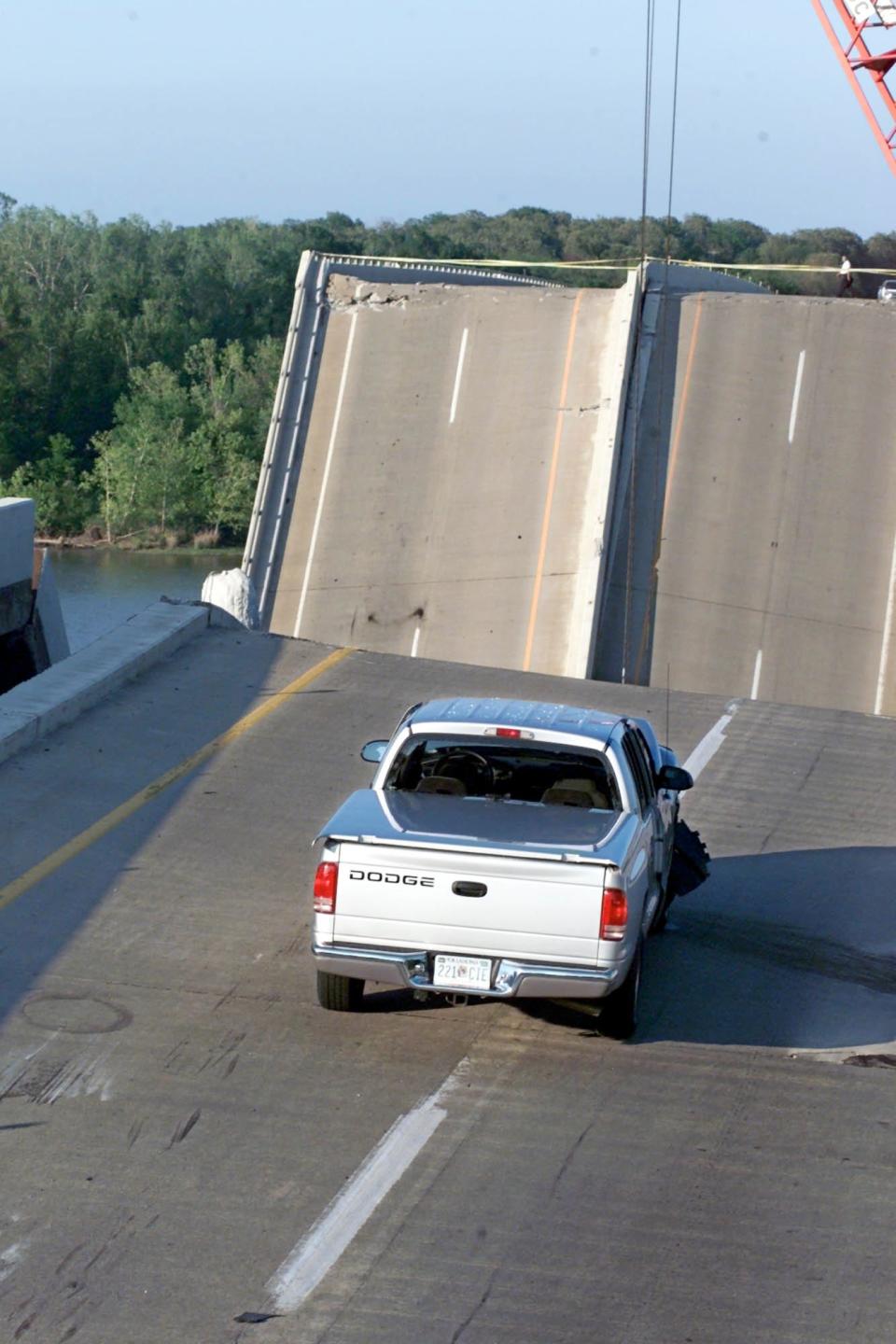 A car from which two people were rescued sits precariously close to the edge of a collapsed portion of Interstate 40 near Webbers Falls.