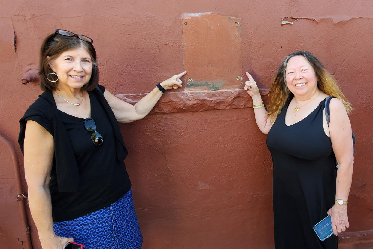 Image: Heather Clifton, left, and Linda Lung, descendants of families in historic Chinatown, point to the space where the plaque used to hang in Denver. (Soon Beng Yeap)