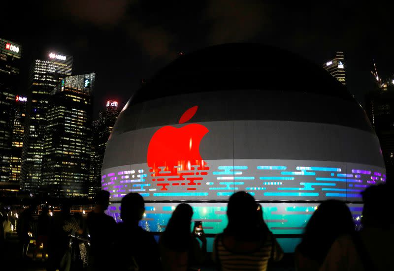 People take photos of the upcoming Apple store at the Marina Bay Sands in Singapore