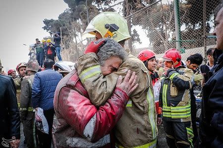 Firefighters react at the site of a collapsed high-rise building in Tehran, Iran January 19, 2017. Tasnim News Agency/Handout via REUTERS