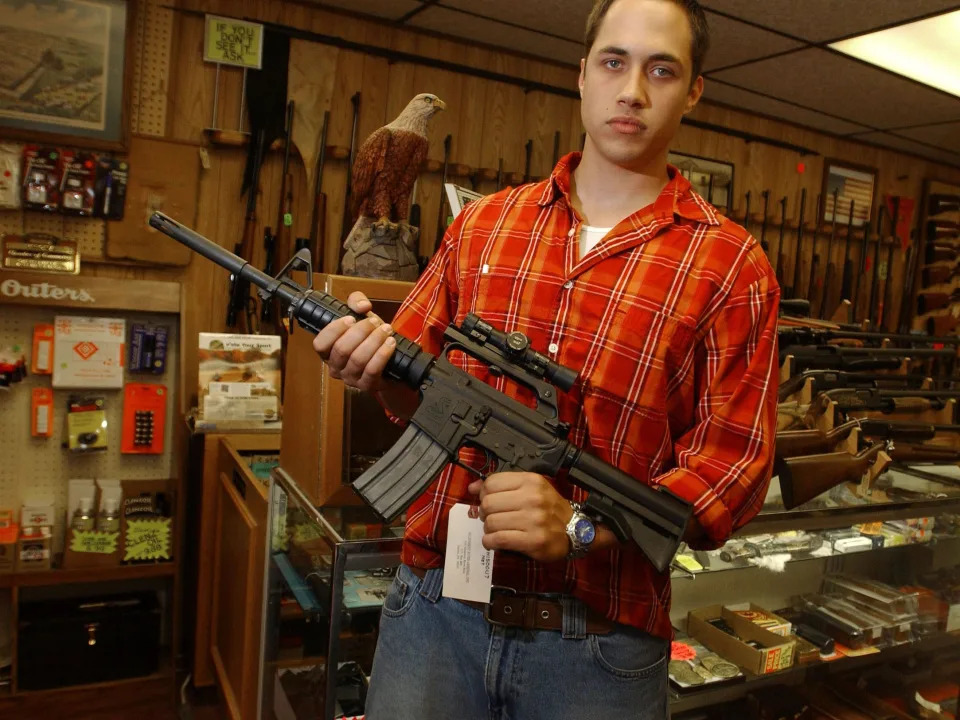 A gun salesman holds an AR-15 with a bayonet mount at a Pittsburgh gun shop in 2004.