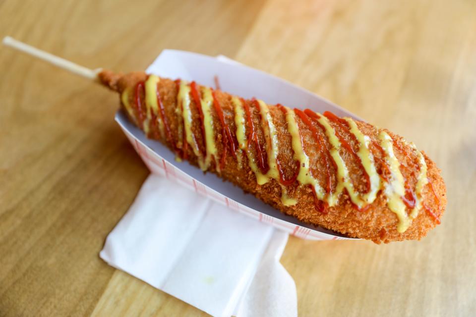 A sausage Korean corndog is served with ketchup and honey mustard at Bop Cha on Friday, July 14, 2023 in Woodburn, Ore. 