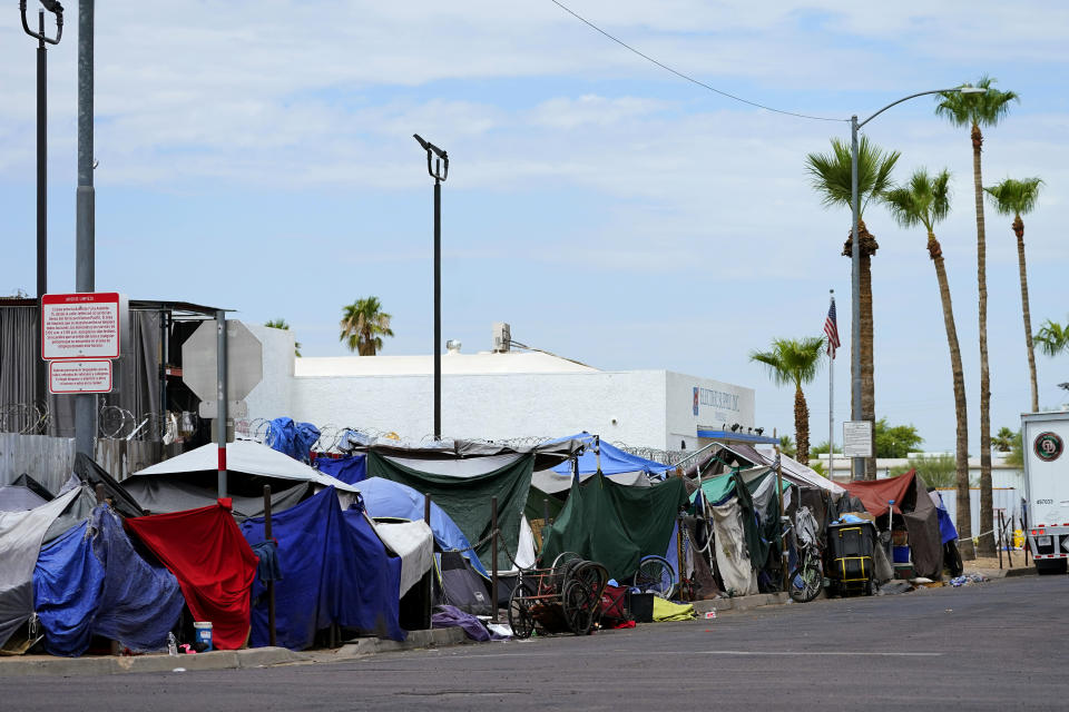 FILE - Tents line the street of "The Zone," a homeless encampment, Tuesday, July 11, 2023, in Phoenix. thousands of homeless people who died this year and are being remembered at winter solstice events for Homeless Persons' Memorial Day. (AP Photo/Matt York)