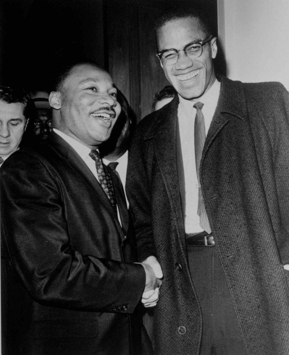 Dr. Martin Luther King Jr. (left) and Malcolm X (right) smile for photographers in 1964.