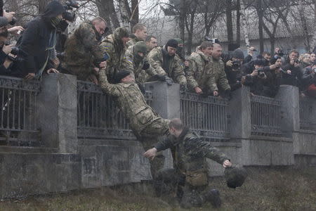 A Ukrainian serviceman guarding Ukraine's Defence Ministry tries to arrest a member of the Aydar battalion who entered the ministry compound, during a protest against the disbanding of the battalion in Kiev, Ukraine, in this February 2, 2015 file photo. REUTERS/Valentyn Ogirenko/Files