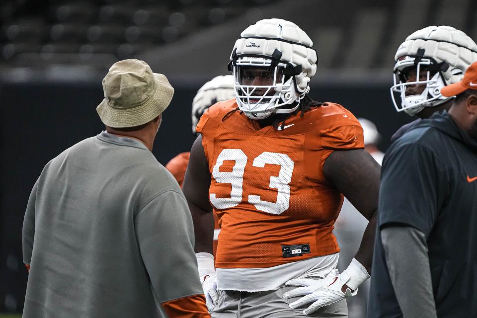 Texas Longhorns defensive lineman T'Vondre Sweat (93) listens to defensive line coach Bo Davis during practice at the Superdome on Thursday, Dec. 28, 2023 in New Orleans, Louisiana. The Texas Longhorns will face the Washington Huskies in the Sugar Bowl on January 1, 2024.