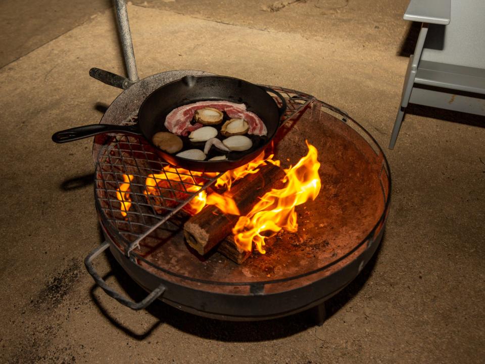 Food on a cast iron over a fire pit