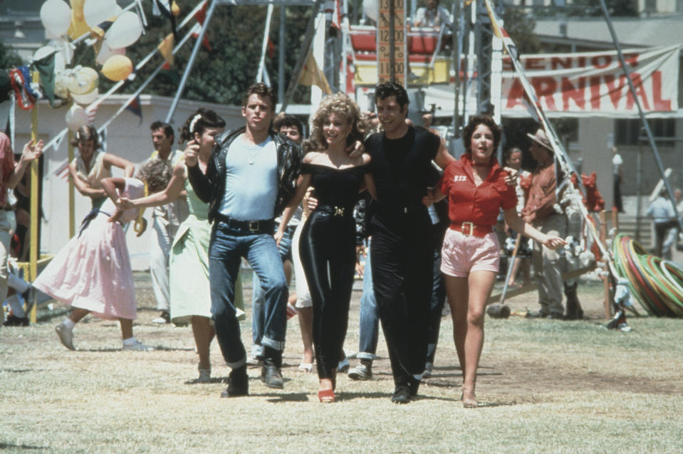 1978:  Left to right: actors Jeff Conaway, Olivia Newton-John, John Travolta and Stockard Channing walk arm in arm at a carnival in a still from the film, 'Grease' directed by Randal Kleiser.  (Photo by Paramount Pictures/Fotos International/Getty Images)