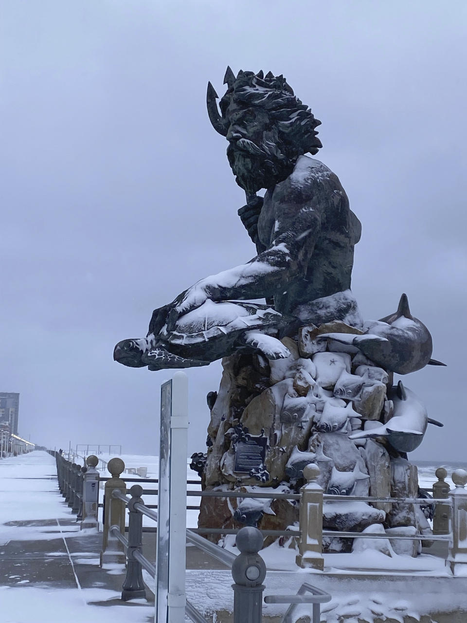 The Virginia Beach oceanfront covered in snow Saturday, Jan. 22, 2022 in Virginia Beach, Va. A layer of ice and a blanket of snow has covered coastal areas stretching from South Carolina to Virginia. The winter weather system that entered the region on Friday brought colder temperatures and precipitation not often seen in the region. (Stacy Parker/The Virginian-Pilot via AP)