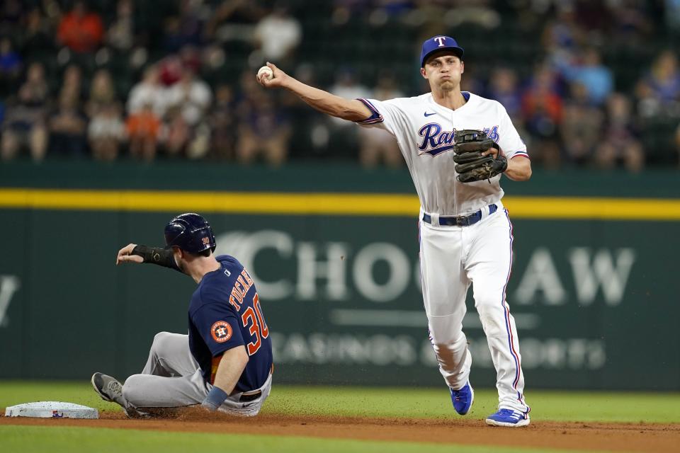 Texas Rangers shortstop Corey Seager throws to first to complete a double play after forcing out Houston Astros' Kyle Tucker at second during the first inning of a baseball game in Arlington, Texas, Tuesday, Aug. 30, 2022. Yuli Gurriel was out at first. (AP Photo/Tony Gutierrez)