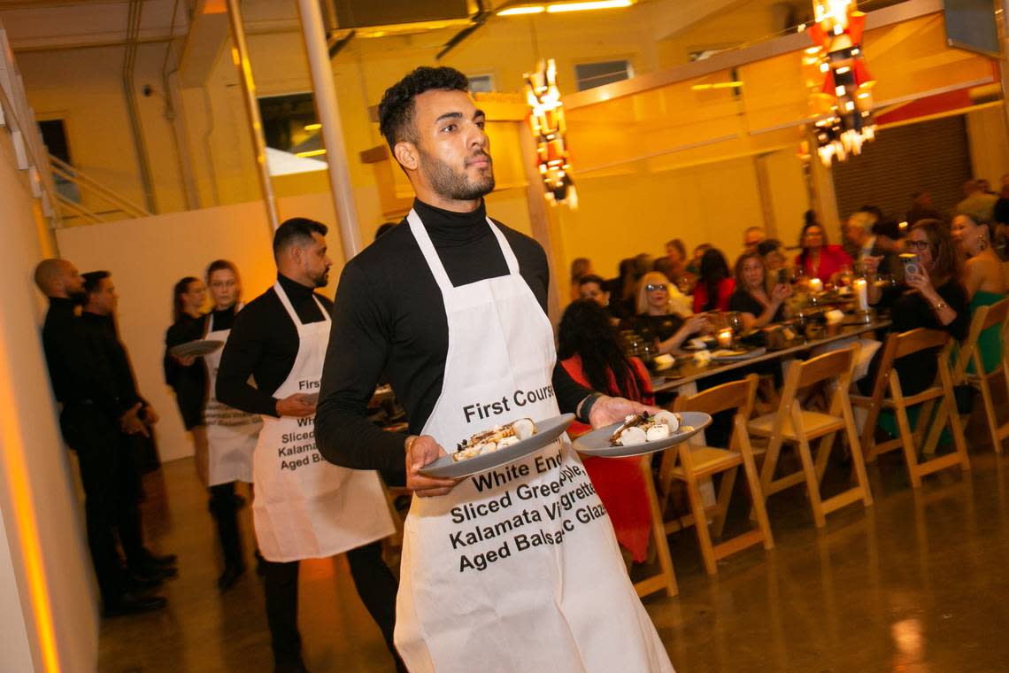 A waiter brings out black and white food during arts nonprofit Locust Projects’ 25th anniversary dinner at its new Little River Location.